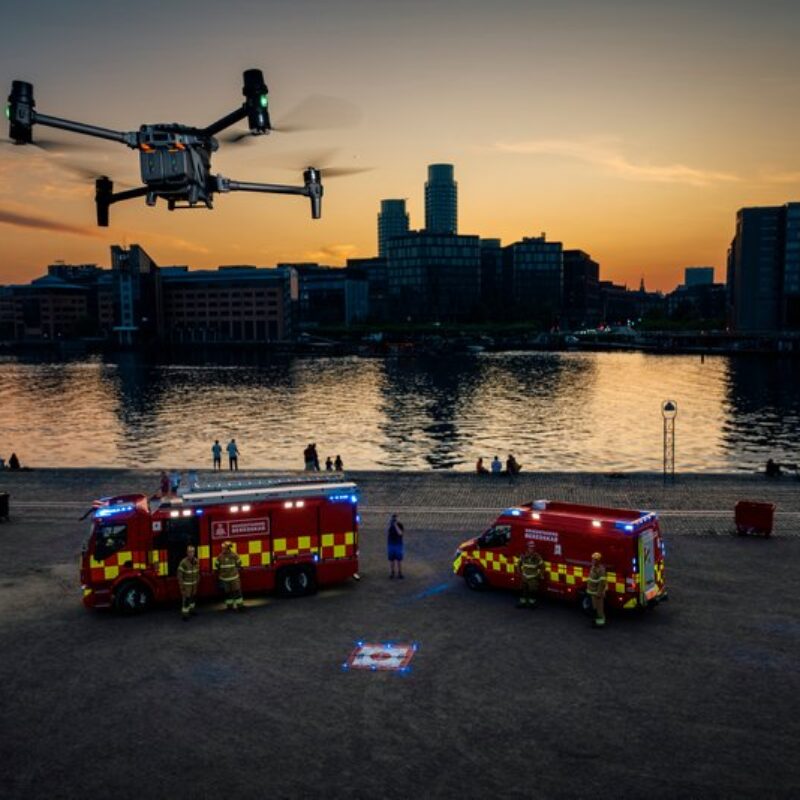 Drone svævende over to brandbiler i tusmørket ved Københavns havn